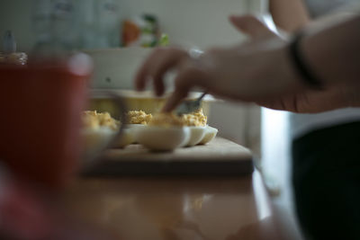 Cropped image of person preparing eggs on table