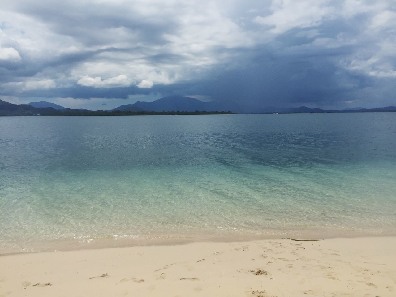 beach, water, sky, sea, tranquil scene, tranquility, sand, scenics, shore, beauty in nature, cloud - sky, nature, cloudy, cloud, idyllic, mountain, coastline, remote, day, outdoors