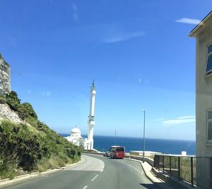 Cars on road against blue sky