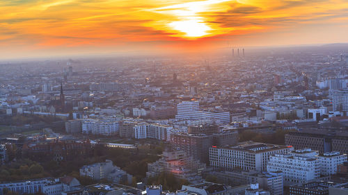 Aerial view of cityscape against sky during sunset