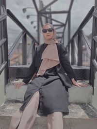 Young woman wearing sunglasses on railing