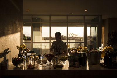 Man standing by glass window on table