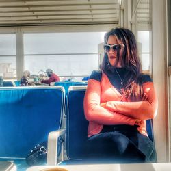 Woman wearing sunglasses sitting in bus