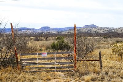 Wooden posts on field against sky