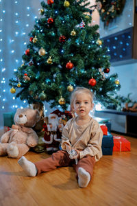 Portrait of cute girl decorating christmas tree at home