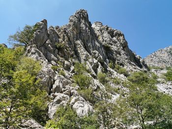 Low angle view of rocks against clear sky