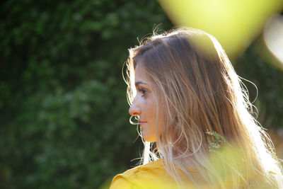 Rear view of young woman looking away outdoors