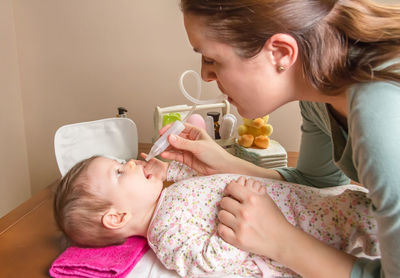 Side view of cute girl holding doll