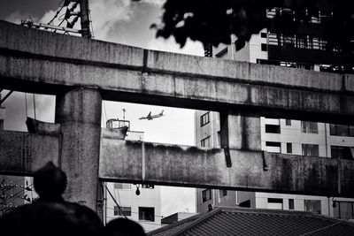 Low angle view of airplane seen through shrine against building