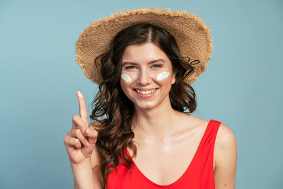 Portrait of a smiling young woman against blue background