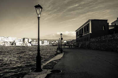 Street light by building against sky