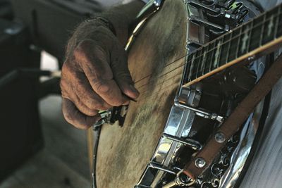 Cropped image of person playing banjo