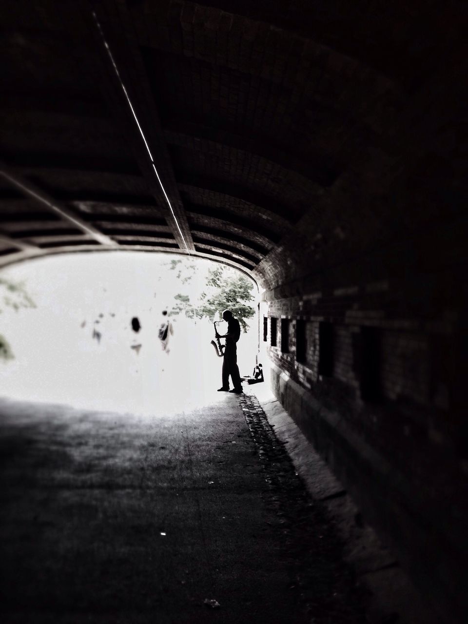 lifestyles, full length, tunnel, indoors, leisure activity, walking, men, the way forward, rear view, illuminated, person, architecture, built structure, on the move, transportation, silhouette, wall - building feature
