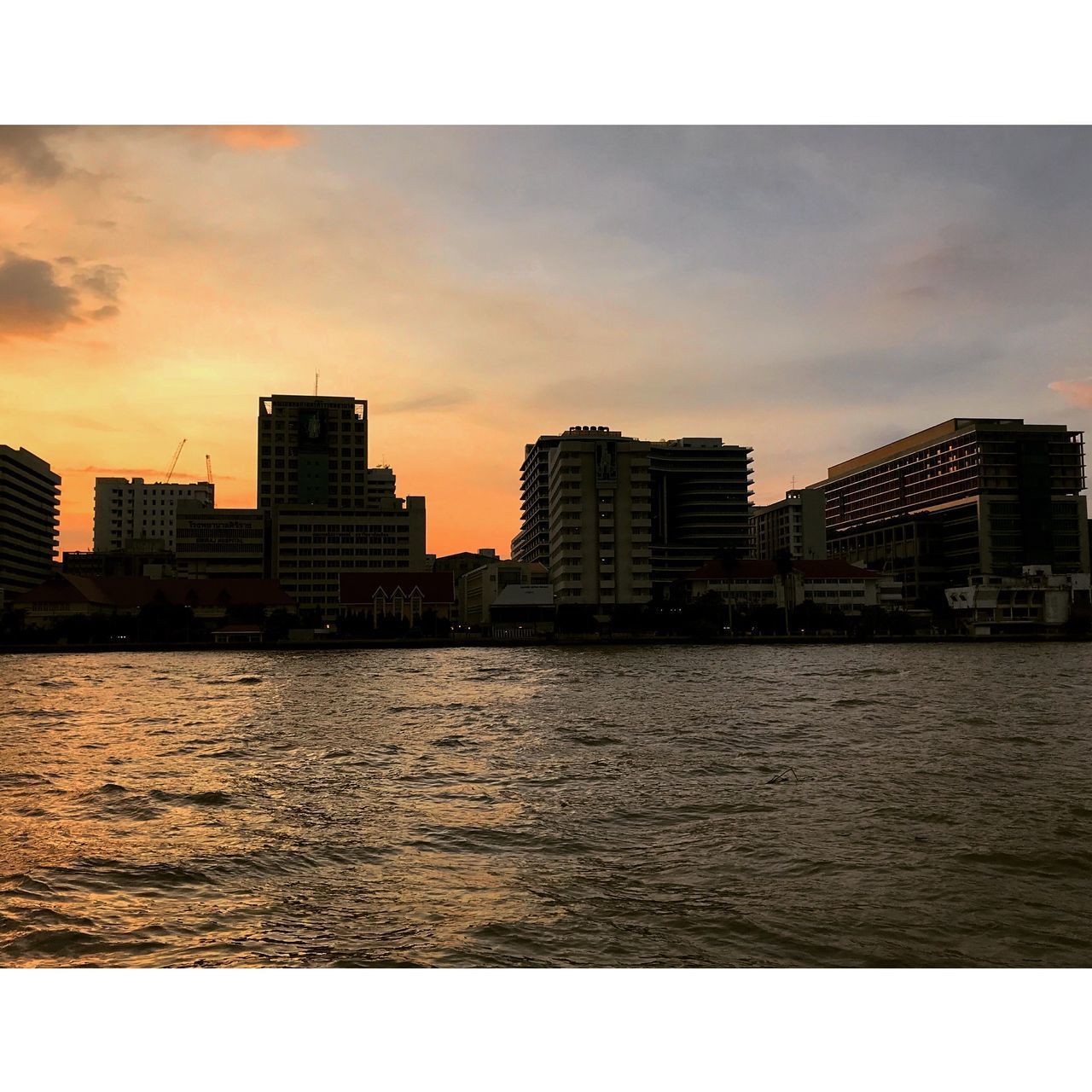 SEA BY CITYSCAPE AGAINST SKY