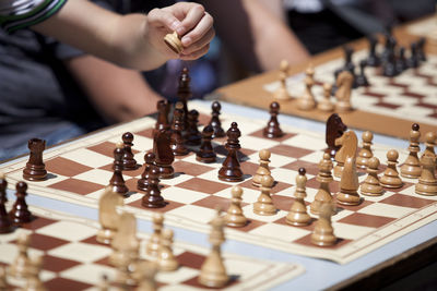 Cropped hands of man playing chess on table