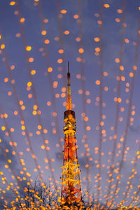 Low angle view of illuminated building against sky during sunset