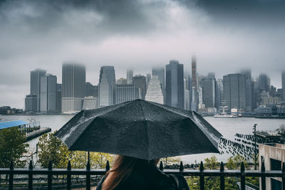 Woman holding umbrella while enjoying view of cityscape