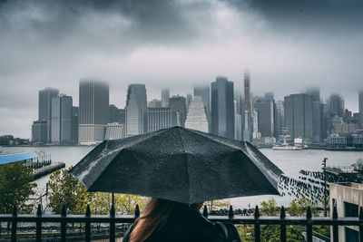 Buildings in city against sky during rainy season