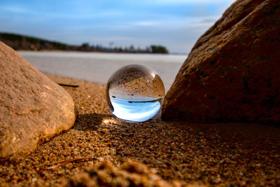 Close-up of crystal ball on beach