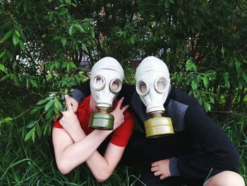 Portrait of friends wearing gas masks in garden