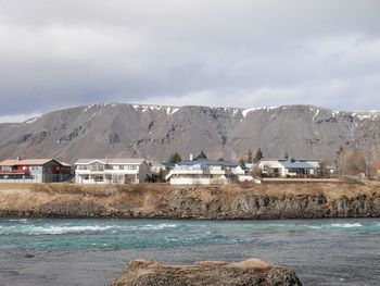 Scenic view of sea and buildings against sky