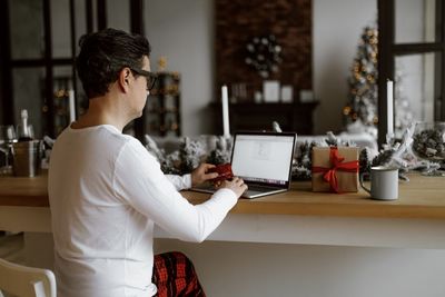 Man holding credit card using laptop at home