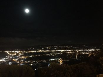 Illuminated cityscape against sky at night