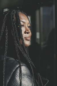 Businesswoman with braided hair looking away near office