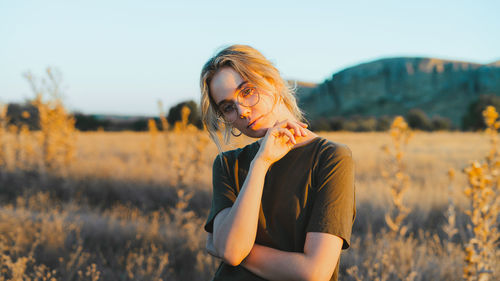 Midsection of woman standing on field against sky