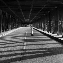 Rear view of woman walking on bridge