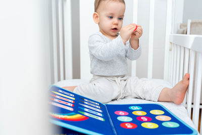 Portrait of cute baby boy using digital tablet at home