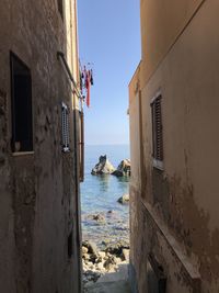 Buildings by sea against clear sky