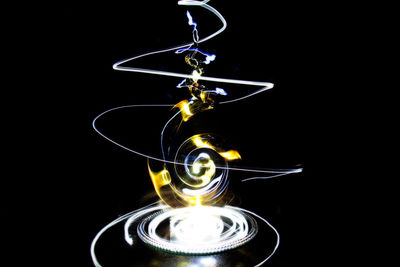 Close-up of illuminated lamp over black background