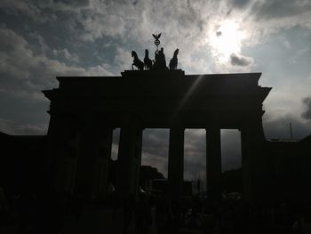 Low angle view of brandenburg gate against cloudy sky