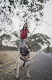 Woman with dog standing outdoors