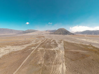 Scenic view of desert against blue sky