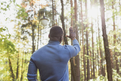 Rear view of man standing in forest