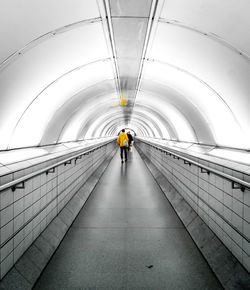 Rear view of man on escalator in tunnel