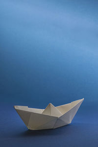 High angle view of paper boat against blue background