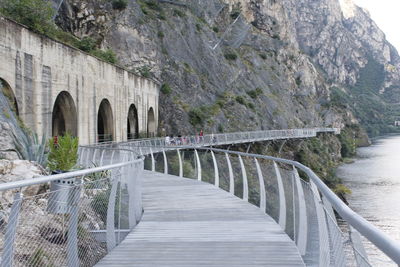 Arch bridge on footpath by mountain