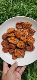 High angle view of hand holding bread in plate