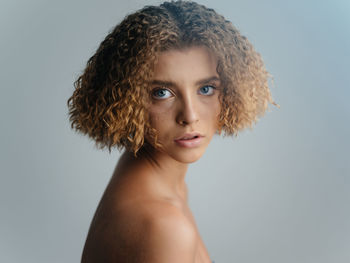 Portrait of young woman against gray background