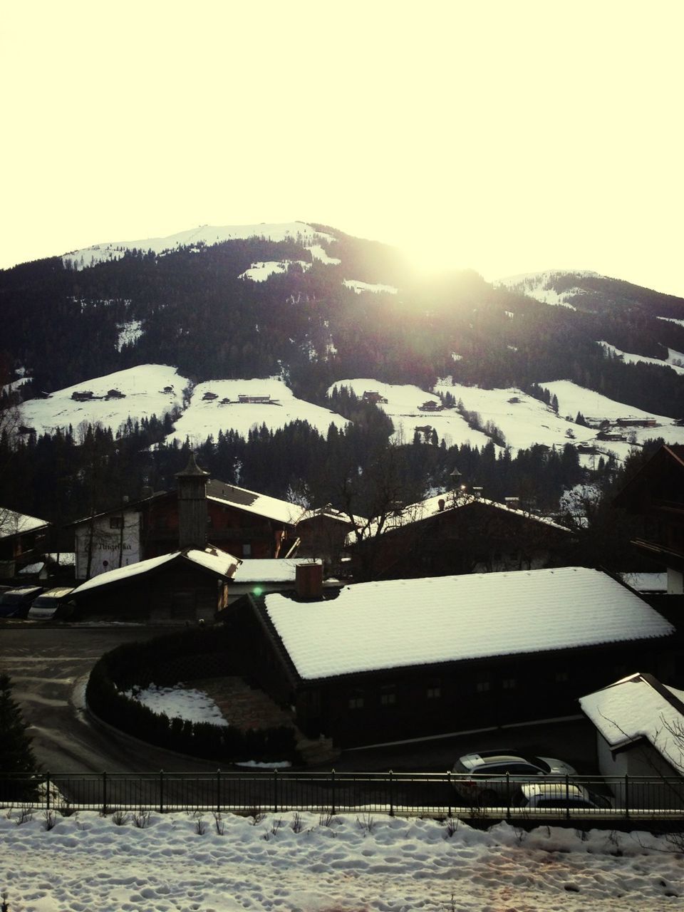 snow, winter, cold temperature, season, building exterior, mountain, built structure, clear sky, architecture, weather, house, frozen, covering, nature, snowcapped mountain, residential structure, mountain range, landscape, sunlight, outdoors