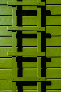 Avocado green color painted wood siding with matching trellis detail of home exterior 