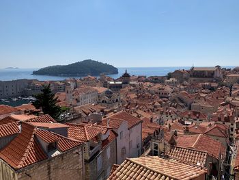 High angle view of townscape by sea against clear sky