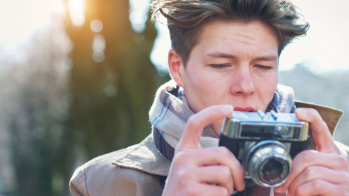 Close-up of young man holding camera