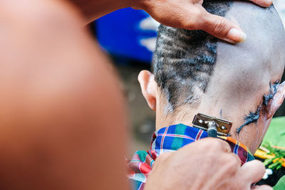 Close-up of man shaving head of boy