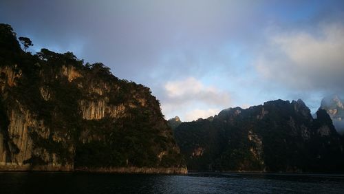 Scenic view of sea and mountains against sky