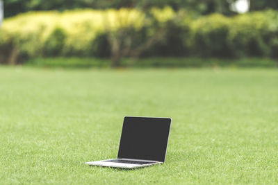 Close-up of laptop on field