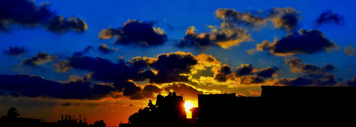 Silhouette of building against cloudy sky